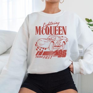 a woman wearing a white sweatshirt and black shorts