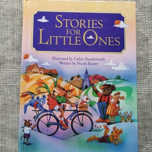 May include: A children's book titled "Stories for Little Ones" with illustrations of animal characters. The cover shows a rabbit on a bicycle, a bear waving, and other animals in a colourful landscape.