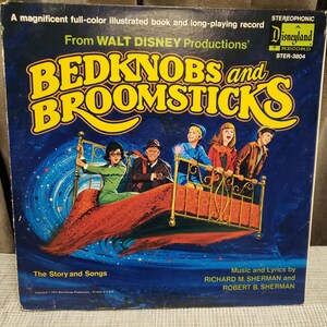 May include: Vintage "Bedknobs and Broomsticks" Disneyland record album cover. The cover features a colorful illustration of characters on a flying bed against a starry background. The album includes "The Story and Songs" by Richard M. Sherman and Robert B. Sherman.