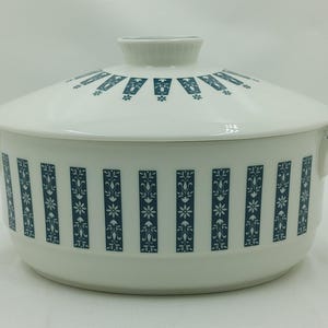 May include: White ceramic serving dish with a blue and white floral pattern. The dish has a lid and two handles.