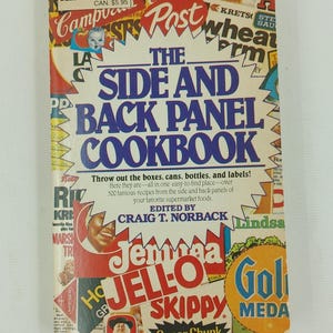 以下が含まれることがあります： 「The Side and Back Panel Cookbook」というタイトルのヴィンテージの料理本。青い表紙に、ジェロ、スキッピー、ゴールドメダルなどの人気ブランドのカラフルな製品ラベルが貼られています。この本には、「箱、缶、瓶、ラベルを捨ててください！ ここに、お気に入りのスーパーマーケットの食品の側面と背面のパネルから、簡単に見つけられる場所に、500以上の有名なレシピがあります。 編集：クレイグ・T・ノルバック。」という文章が書かれています。