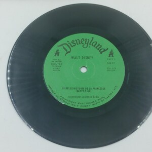May include: A vintage black vinyl record with a green label featuring the Disneyland logo and "Walt Disney" text. The label also includes French text: "LA BELLE HISTOIRE DE LA PRINCESSE NATT&Eacute; D'OR".