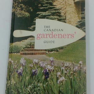 May include: A vintage book titled "The Canadian Gardeners' Guide." The cover features a garden scene with a path, steps, and flowers. The title is in white and pink, set against a trowel illustration.