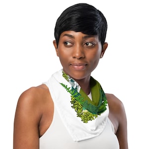 This is an image of a brown woman wearing the green mushroom scarf tied around her neck.