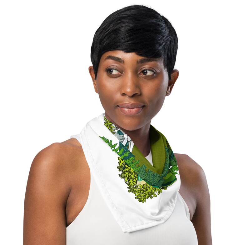 This is an image of a brown woman wearing the green mushroom scarf tied around her neck.