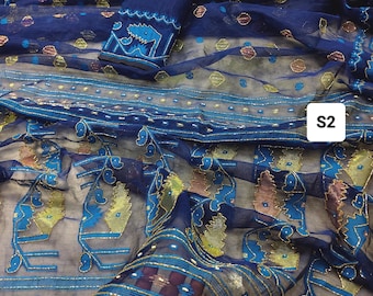 May include: A navy blue fabric set with intricate gold and turquoise embroidery. The set includes a top with detailed patterns and a matching fabric piece. The fabric has a sheer quality, with a delicate, flowing drape. The text "S2" is visible.