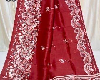 May include: A deep red textile with intricate white floral and geometric patterns. The fabric has a glossy sheen and is draped, showcasing the detailed design along the borders and edges. The text "S8" is visible in the upper left corner.