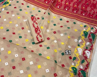 May include: A beige saree with a red, white, green, and yellow geometric pattern. The saree has a red border with a white and yellow design. The saree is made of a sheer fabric and has a matching blouse piece.