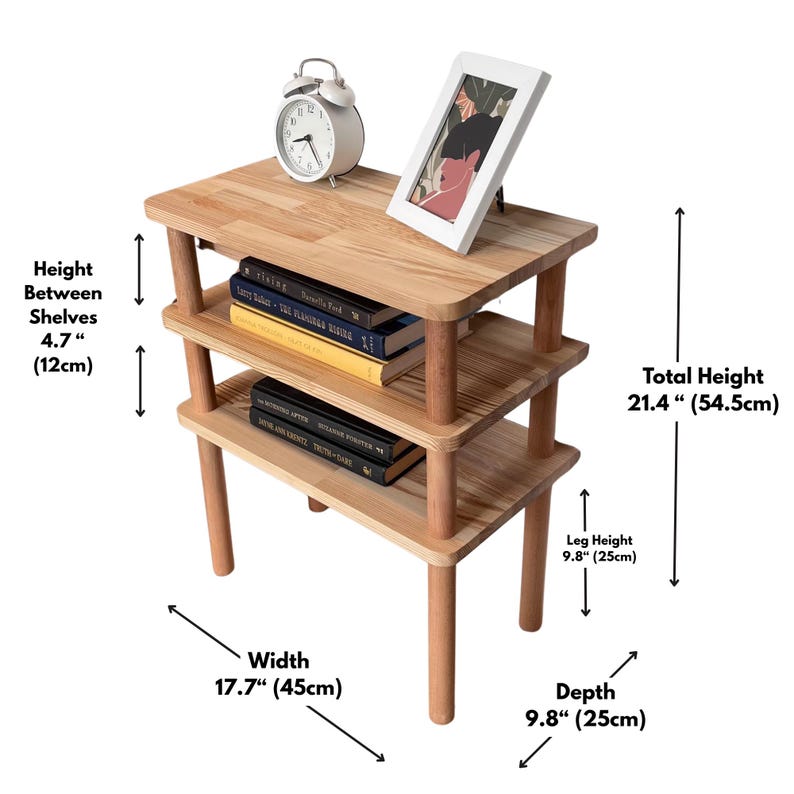 Puede incluir: Una mesa auxiliar de madera de tres niveles con un acabado de madera clara. La mesa tiene una altura total de 54,5 cm, una anchura de 45 cm y una profundidad de 25 cm. La altura de las patas es de 25 cm y la altura entre estantes es de 12 cm.