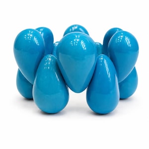 May include: A bright turquoise bracelet. The bracelet features multiple teardrop-shaped beads, arranged in a circular design. The beads have a smooth, glossy finish, reflecting light. The bracelet is presented on a plain white background, highlighting its colour.