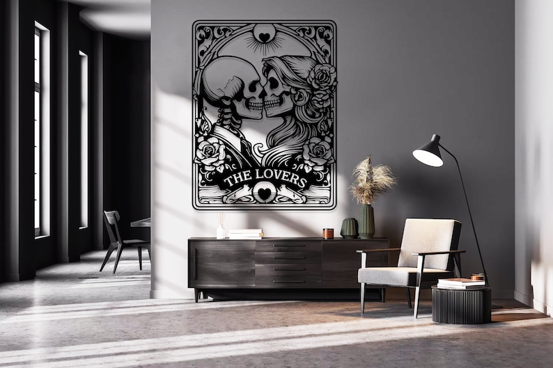 May include: A black and white wall art piece featuring a tarot card design titled THE LOVERS. The illustration depicts two skeletons facing each other in a romantic pose, surrounded by intricate floral patterns, roses, and a sun symbol above.