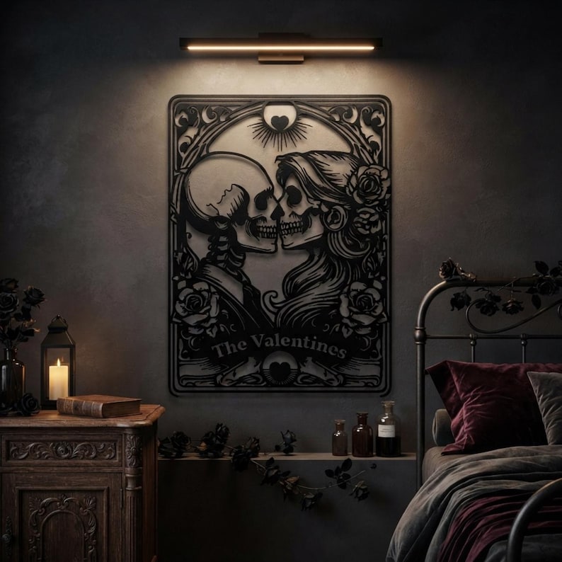 May include: A black metal wall art piece featuring a cutout design of two skeletons facing each other in a romantic pose, surrounded by roses and ornate filigree. The text The Valentines is centered at the bottom below the two figures.