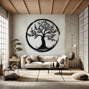 Peut inclure: D&eacute;coration murale en m&eacute;tal noir en forme d'arbre de vie avec un design circulaire. L'&oelig;uvre d'art est accroch&eacute;e &agrave; un mur blanc dans un salon avec un canap&eacute;, une table basse et des plantes.