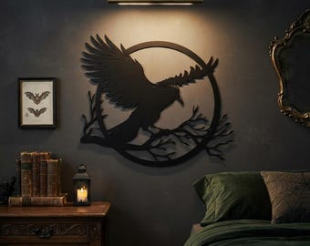 May include: A black metal wall art piece featuring a silhouette of a raven with wings spread wide, perched on a branch within a circular frame. The design is mounted on a dark wall directly beneath a horizontal brass-toned light fixture.