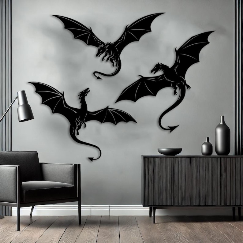 以下が含まれることがあります： 黒い金属製のドラゴンの壁掛けアート3点。各ドラゴンは翼を広げ、長い尾を持っています。 ドラゴンは灰色の壁に取り付けられており、ドラマチックでファンタジーをテーマにした装飾を作り出しています。