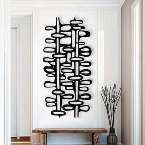 May include: Black metal wall art featuring a geometric design of overlapping circles and lines. The artwork is mounted on a white wall above a wooden bench.