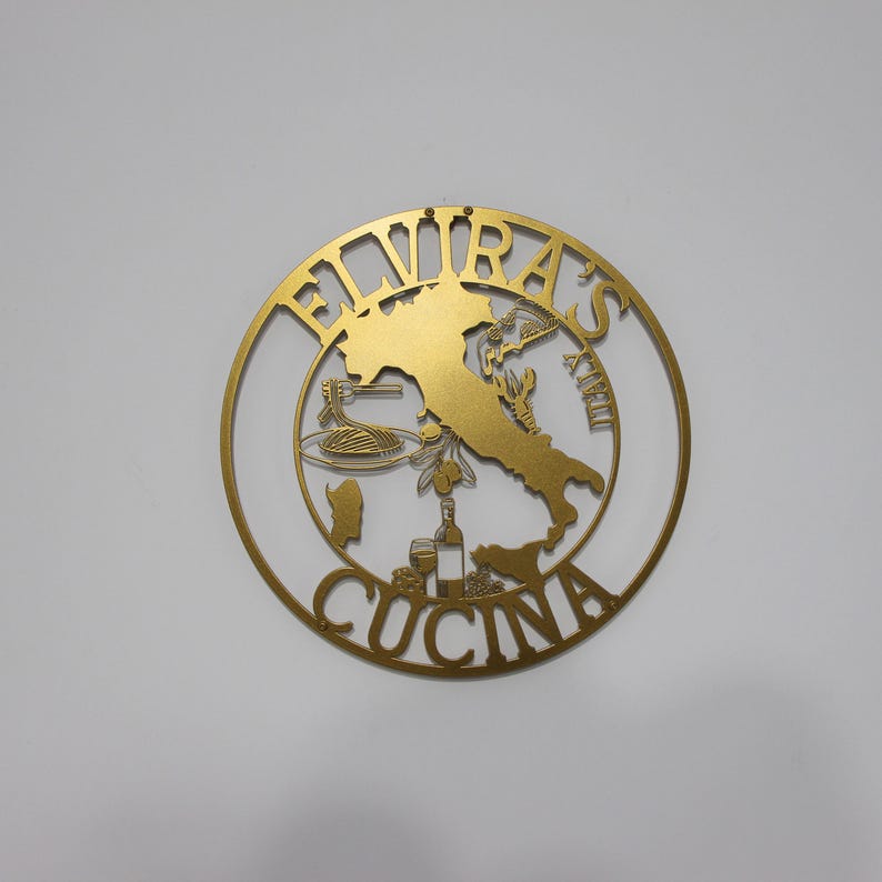 Może przedstawiać: Złoty metalowy znak z napisem "Elvira's Cucina" w k&oacute;łku. Znak przedstawia sylwetkę Włoch z r&oacute;żnymi ikonami włoskiego jedzenia.