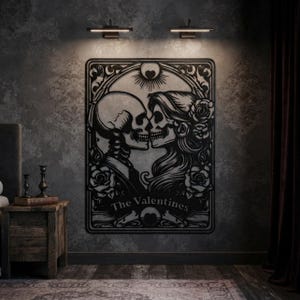 May include: A black metal wall art piece featuring a stylized illustration of two skeletons facing each other in a romantic pose, surrounded by roses and ornate filigree patterns, with the text The Valentines printed at the bottom center.