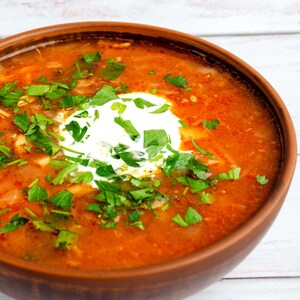 Peut inclure: Un bol de soupe rouge borscht surmonté d'une cuillerée de crème fraîche et de persil frais.
