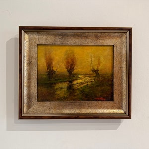 Può includere: Un dipinto ad olio incorniciato che raffigura tre alberi in un paesaggio nebbioso. Gli alberi sono in silhouette contro un cielo dorato, e l'acqua in primo piano è di un verde scuro.