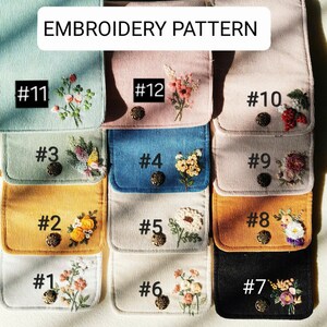 Pu&ograve; includere: Una collezione di pochette in velluto a coste di vari colori, ognuna con ricami floreali unici e una chiusura con bottone decorativo. Le pochette sono numerate e il testo "EMBROIDERY PATTERN" &egrave; in alto.