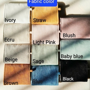 Pu&ograve; includere: Campioni di tessuto di velluto a coste in vari colori, tra cui avorio, paglia, rosa blush, azzurro e nero. Ogni campione &egrave; etichettato con il nome del colore, fornendo una guida visiva per la selezione del tessuto.