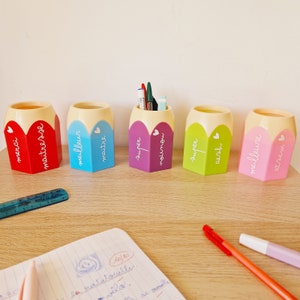Peut inclure: Cinq organiseurs de bureau en forme de crayon de couleur avec différents messages écrits dessus. Les messages sont "merci", "maître d'ose", "meilleur maître", "super mignon", "super oesh" et "meilleure d'azam".