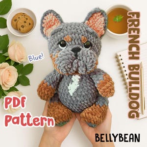 Może przedstawiać: Wzór na szydełku na amigurumi zabawkę w kształcie francuskiego buldoga. Wzór jest dostępny jako plik PDF do pobrania. Gotowa zabawka jest szara z brązowymi akcentami i ma niebieskie tło.