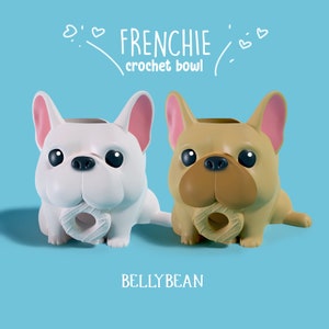Puede incluir: Dos cuencos de crochet con forma de bulldog francés, uno blanco y otro marrón, con un agujero en forma de donut en la parte delantera. Los cuencos están etiquetados como "FRENCHIE crochet bowl" y "BELLYBEAN".
