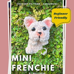 May include: A crochet pattern for a Mini Frenchie amigurumi. The pattern is labeled "Beginner Friendly." The finished product is a small, white dog with pink ears and a black nose. The text "Mini Frenchie by Bellybean" is also visible.