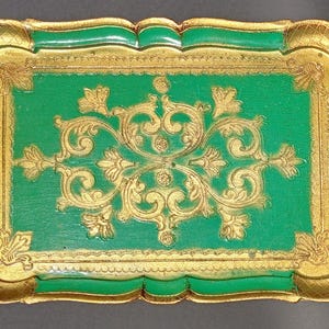 May include: A green and gold decorative tray with a scalloped edge and a gold floral design.