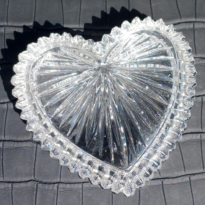 Crystal heart dish open on dark background showing cut pattern details.