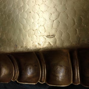 May include: Close-up of a hammered brass tray with a scalloped edge. The tray has a textured surface and a dark patina. The word "WESAM" is stamped on the surface.
