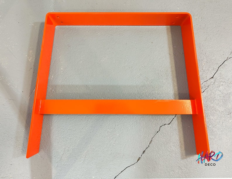 May include: Orange metal frame for a shelf or table. The frame is made of thick metal and has a simple, modern design.