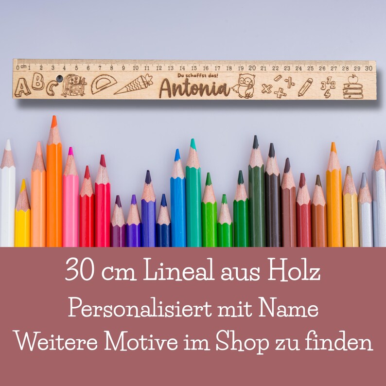 May include: A wooden ruler with a personalized name "Antonia" and a variety of school-themed illustrations, including letters, numbers, a pencil, a ruler, a carrot, an owl, and a stack of books. The ruler is 30 inches long and is surrounded by a row of colored pencils.