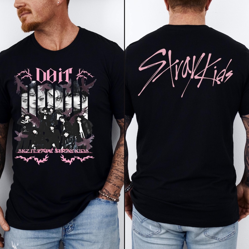 K&ouml;nnte beinhalten: Schwarzes T-Shirt mit einem rosa Grafikdesign. Auf der Vorderseite stehen die Texte "DOIR" und "SKZ IT TAPE STRAY KIDS" zusammen mit Bildern von Personen. Auf der R&uuml;ckseite des T-Shirts steht der Text "Stray Kids" in Rosa.