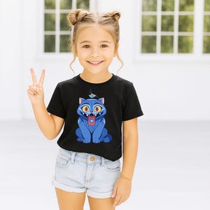 May include: A black t-shirt featuring a cartoon blue cat with yellow eyes and a red tongue. A small blue bird sits atop the cat's head. The child is wearing light blue denim shorts.