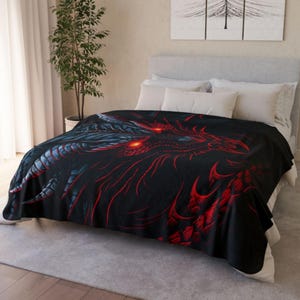 Può includere: Coperta nera con un disegno di drago rosso e nero. Il drago ha occhi rossi luminosi e dettagli intricati. La coperta è su un letto con cuscini bianchi e un tappeto neutro.