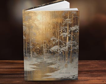 May include: Hardcover journal with a winter forest scene. The cover features a painting of a snowy forest with a river, trees, and a bright, golden light. The text "Custom Journal" is at the bottom.