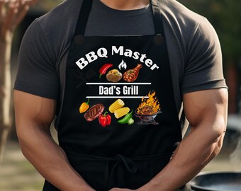 May include: Black apron with the text "BBQ Master Dad's Grill" and illustrations of grilled food. The apron features images of a baked potato, a grilled chicken leg, a steak, corn on the cob, peppers, and a grill with flames.