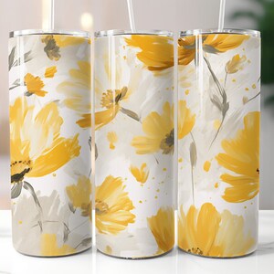 Puede incluir: Tres vasos de acero inoxidable con un patrón floral amarillo. Los vasos tienen un fondo blanco con flores amarillas y tallos grises. Las flores están pintadas en un estilo acuarela.