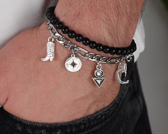 May include: A black beaded bracelet with a silver chain and charms, including a cowboy boot, compass, triangle, and crescent moon.