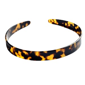 May include: A brown and black tortoiseshell headband.