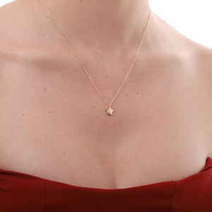 May include: A gold chain necklace with a small star pendant.