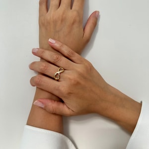 14K gold infinity symbol ring with a shiny and smooth surface. It has no gemstones on it.