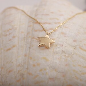 14K gold star pendant necklace with a fine chain. It has a curved and shiny surface. You can order this star shaped necklace in 3 different color options.