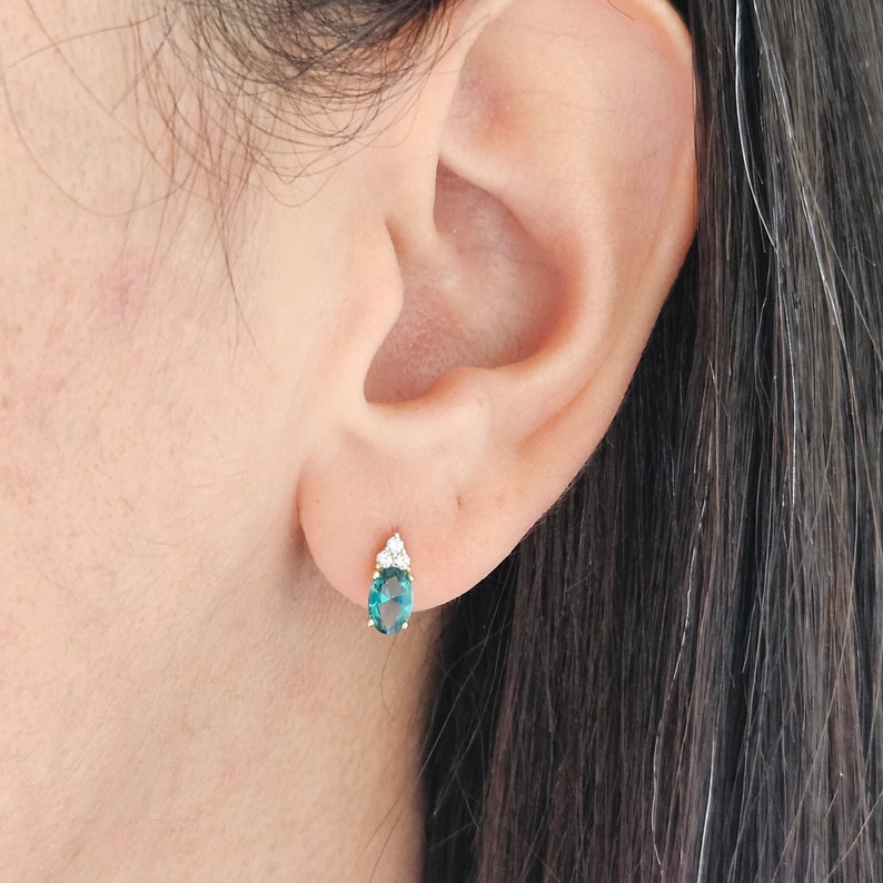 14K goldoval cut emerald screw back earrings.