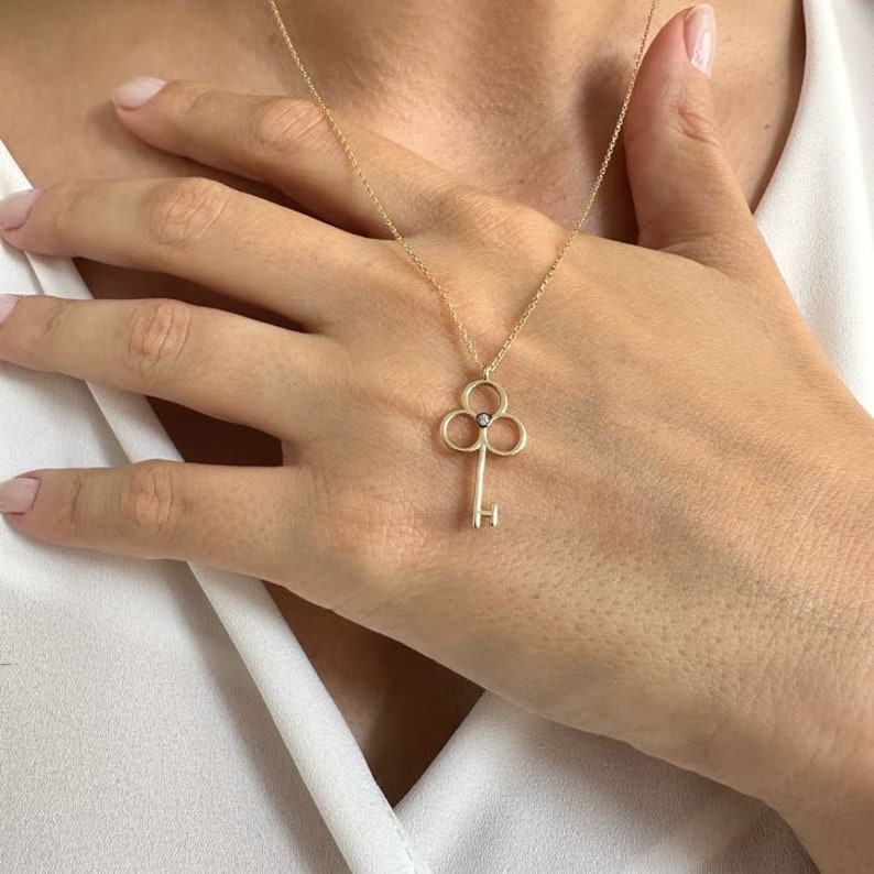 14K dainty gold key necklace with a fine chain. There is a little zircon in the middle of the handle of the key. It is available in three different color options.