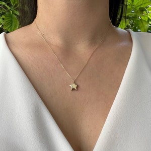 May include: A gold chain necklace with a small, star-shaped pendant.