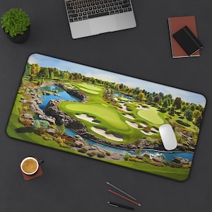 Peut inclure: Tapis de souris rectangulaire avec une image détaillée d'un parcours de golf. Le design comprend des fairways verts, des bunkers de sable et un plan d'eau. Des arbres, un ciel bleu et un drapeau rouge sur le green sont également visibles.